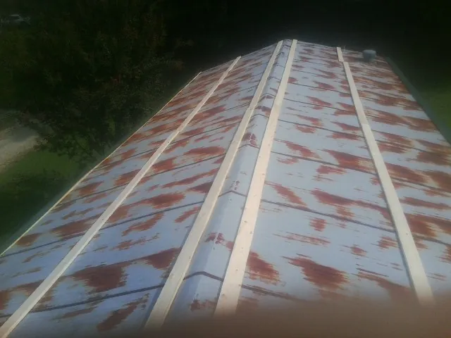 Rusted metal roof panels with new wood purlins before replacement — Storm Damage Roof Repair in Dansville by Roofing Brothers